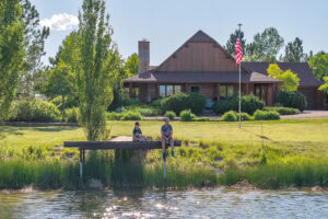 Stocked fishing pond with dock and home in background at horse property for sale near Bushnell Nebraska